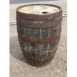 A large oak whiskey barrel, the staves bound by six metal strap bands. (35in)