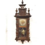 A stained Vienna wallclock, the case with architectural pediment mounted with beehive finials,