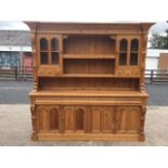 A large pine dresser, the back with breakfront moulded cornice above blind fretwork frieze, having
