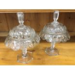 A pair of Irish glass urns & covers, the facet cut domed lids having lozenge shaped hollow