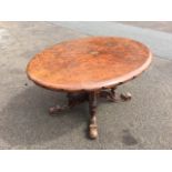 A Victorian oval walnut breakfast table having scalloped rim, supported on scroll carved