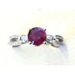 An 18ct white gold ruby & diamond ring, the claw set ruby weighing just under a carat, raised