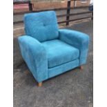 A deco style modern upholstered armchair with square button back and loose cushions framed by