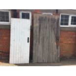A large weathered batten door mounted with iron hinges - 47in x 83in; and a painted tongue &