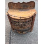 A bowfronted cast iron stove, the scalloped upstand mounted with brass fleur-de-lils, the hinged