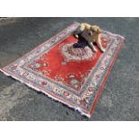 A Belgian oriental style wool rug woven with central floral medallion on maroon field framed by
