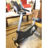 A Cybex Cyclone exercise bike with adjustable padded seat, electronic dashboard, tension control,