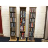 A set of three oak CD racks of column form, containing 102 CDs - mainly classic pop, and 35 DVDs. (