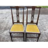 A pair of art nouveau side chairs, the backs with crook rails above fretwork pierced splats, the