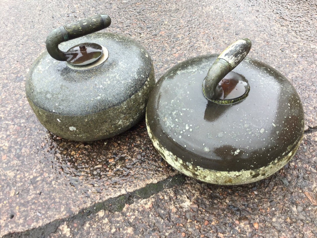 Two Victorian polished granite curling stones with brass & wood handles. (10in) (2)
