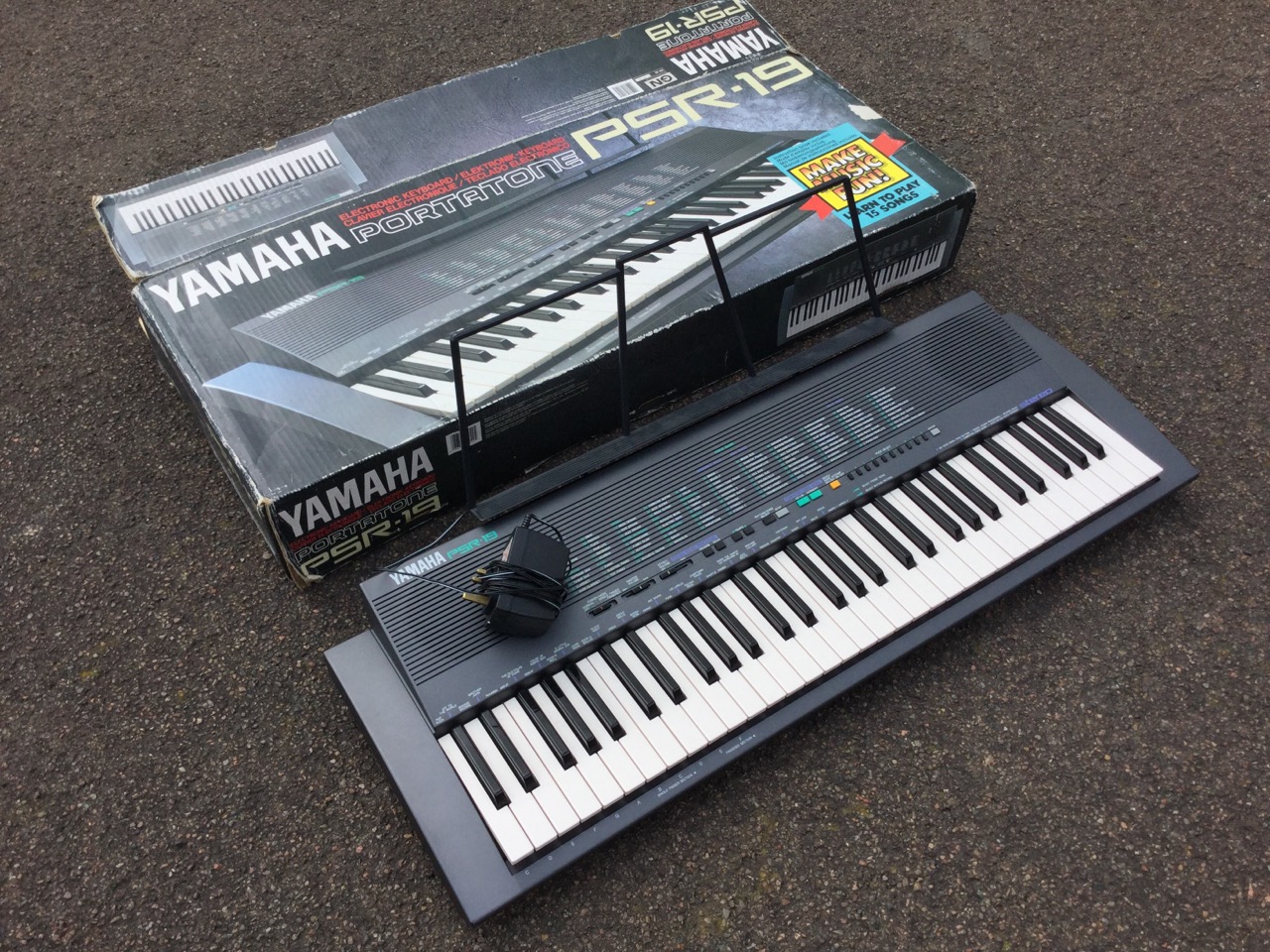 A boxed Yamaha PSR 19 Portatone electronic keyboard, the five octave instrument with 99 effects,