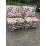A pair of contemporary floral upholstered chairs with loose cushions, having padded arched aprons on