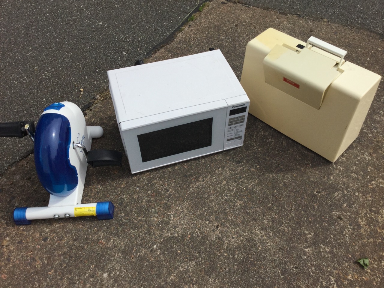 A cased Brother sewing machine; a Panasonic microwave oven; and a Bavina pedal exercise machine. (