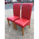 A pair of contemporary red leather upholstered chairs with high backs and sprung seats on square