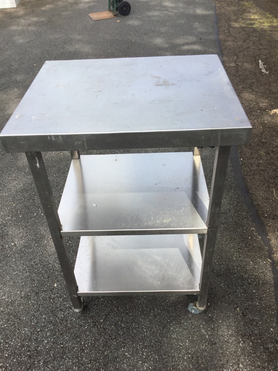 A rectangular stainless steel table with two shelves below, raised on casters. (23.5in x 19.5in x - Image 3 of 3