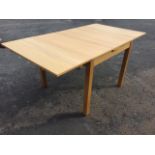 A contemporary oak dining table with drawer leaves raised on square column legs. (36in x 66.5in x