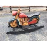 A childs carved & painted hardwood rocking horse motorbike. (40in x 24in)