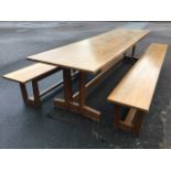 A 10ft rectangular oak refrectory table and two benches, the set raised on twin tapering supports