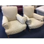 A pair of Edwardian upholstered armchairs, having long sprung upholstered seats on stub cabriole