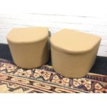 A pair of new tan faux leather pouffes of D shaped outline, the padded stools on black bun feet. (