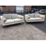 A pair of contemporary Home Centre linen upholstered camel back sofas having loose cushions and