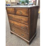 An Edwardian oak chest of drawers, the rectangular moulded top above two short and three long