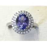 An 18ct gold tanzanite & diamond cluster ring, the oval claw set tanzanite of nearly two carats,