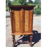 A nineteenth century European walnut cabinet on stand, with moulded cornice above panelled