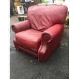 A large leather upholstered armchair with reclining mechanism, having integral footstool.