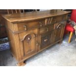 An art nouveau bowfronted oak sideboard, with three scroll carved doors beneath three drawers