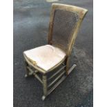 A 20th century rocking chair with cane back & seat, raised on turned legs and stretchers with shaped