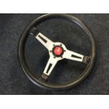 An Italian Momo brushed aluminium three spoke steering wheel with leather mounts. (14.5in)