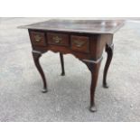 An eighteenth century country oak lowboy, the rectangular moulded two-plank top above three small