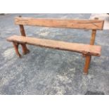 A 6ft rustic style garden bench with shaped plank back and seat on horseshoe shaped supports. (