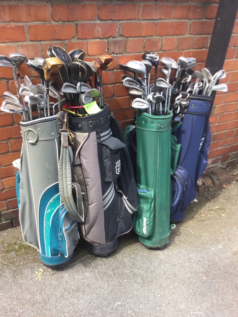 Four golf bags containing approx 80 golf clubs - Spalding, Slazenger, Howson, Fred Smyth, Wilson,