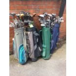 Four golf bags containing approx 80 golf clubs - Spalding, Slazenger, Howson, Fred Smyth, Wilson,