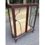 A 50s walnut china cabinet, the rounded top above astragal glazed doors enclosing glass shelves,