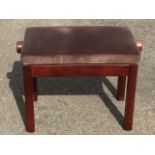 A reproduction mahogany piano stool, the adjustable bench seat with two handles, raised on rounded