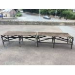 Two rectangular garden potting tables with slatted tops on square column legs joined by