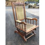 A late Victorian American rocking chair, the back with scroll carved crest above a row of gallery