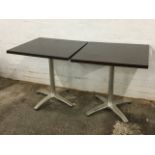 A pair of square tables on aluminium columns, having four splayed legs with bun feet. (27.5in x 27.