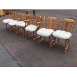 A set of six pine kitchen chairs with pierced splats framed by spindles above shaped seats with