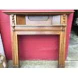 A late Victorian oak chimneypiece with overhanging mantleshelf above a panel and further moulded