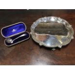 A nineteenth century silver plated scalloped waiter on ball & claw feet; and a cased Victorian