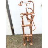 An unused floor standing Hurlingham Bath Company polished copper mixer tap, with integral shower