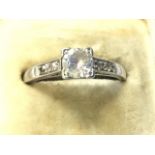 An 18ct platinum diamond ring, the stone of approx .25 carat in square mount having further small