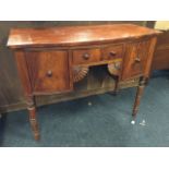 A small nineteenth century bowfronted mahogany sideboard, having central kneehole with cockbeaded