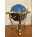 A 9in globe on gilt metal stand with ball feet, united by compass in pierced stretchers, the