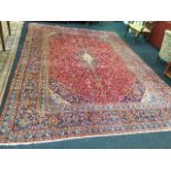 A large Izmir carpet woven with colourful floral field and central oval scalloped medallion on red