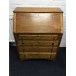 An oak bureau with cleated fallfront enclosing a fitted interior with pigeonholes, the desk with